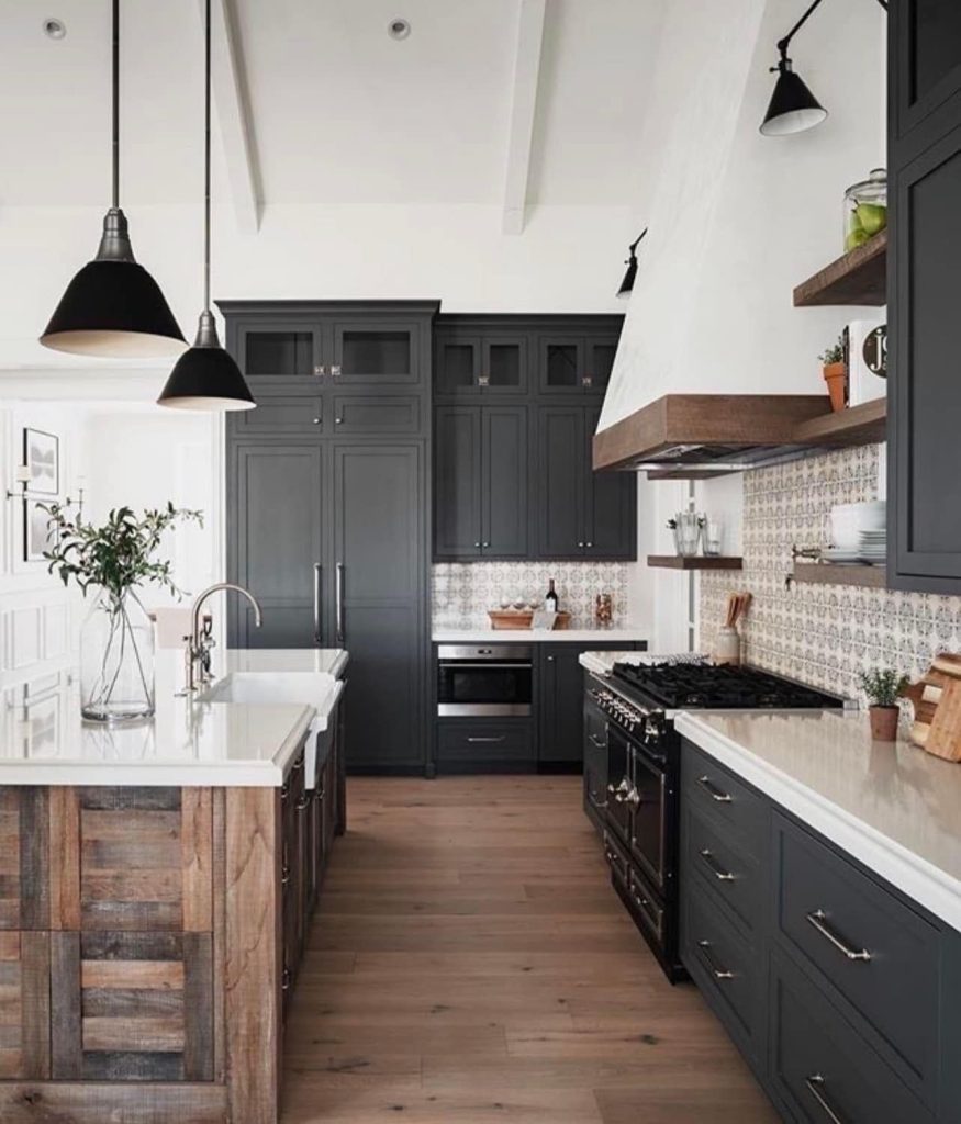 Modern farmhouse kitchen design with black cabinets, wood island, white countertops, and black pendant lights